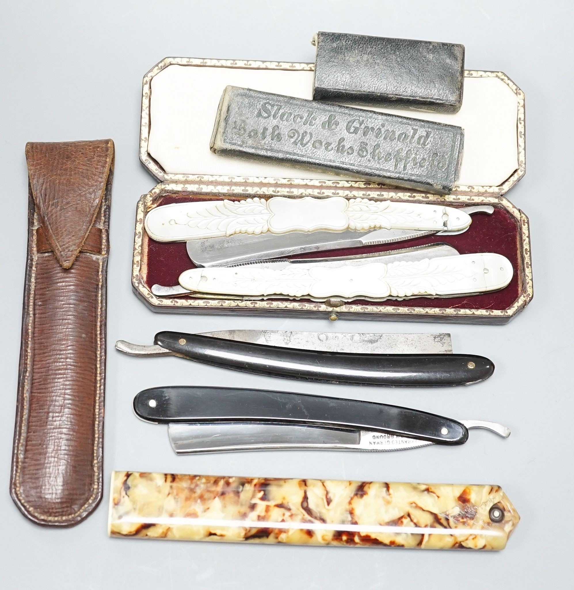 A leather cased pair of mother-of-pearl handled cut throat razors, by J Crawford and three other cased cut throat razors (4)